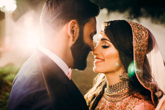 stock-photo-handsome-bearded-indian-groom-kisses-bride-in-pink-dress-tender-standing-outisde-764321713
