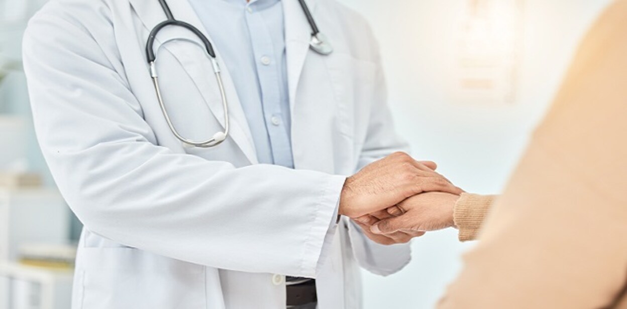 Doctor, patient and helping hand, empathy and communication, comfort and cancer results with kindness. Respect, help and trust, support in healthcare and people in hospital, holding hands and care